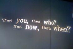 the words are projected on the wall in front of it's light fixture, which reads if not you, then who? if not now, then when?