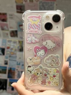 someone is holding up their phone case with stickers on the front and back of it