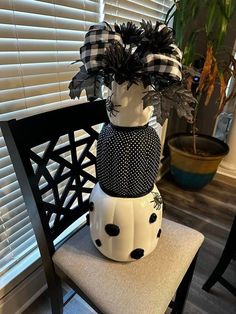 a black and white vase sitting on top of a chair