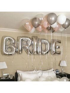 some balloons are hanging from the ceiling above a bed