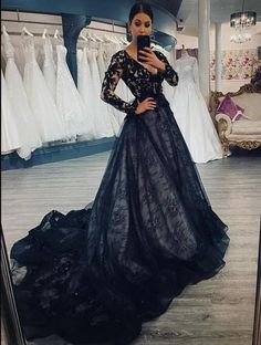 a woman taking a selfie in front of a mirror wearing a black lace dress