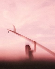 two people standing in front of a pink sky