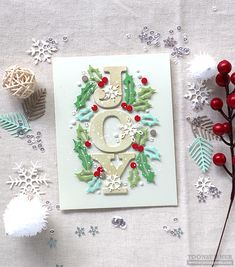 a christmas card with the letter e on it and snowflakes scattered around it