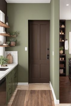 a kitchen with green walls and wooden flooring next to an open door that leads into the dining room