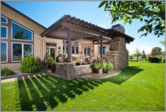 a house with a covered patio in the front yard and grass on the lawn below