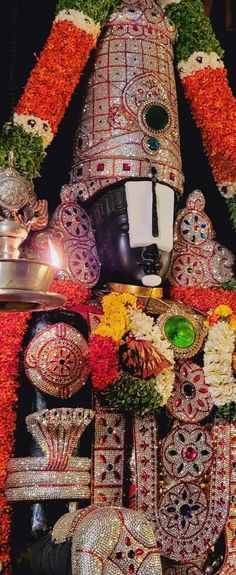 an elaborately decorated statue with flowers and candles