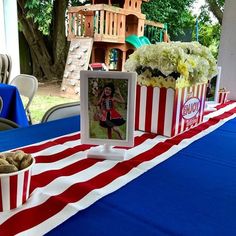 the table is set up with popcorn buckets and pictures on them for an american flag themed party