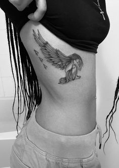 a woman's stomach with an angel tattoo on it