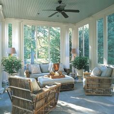 a sun room with wicker furniture and large windows on the ceiling, surrounded by potted plants