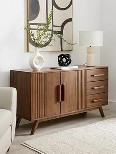 a living room scene with focus on the sideboard and art hanging above it's door