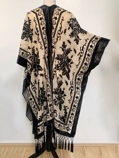 This shawl is absolutely LUSH...very reminiscent of fabulous piece from early 1900s. Would work beautiful over a nice dress or as a robe. The fabric is slightly sheer golden nude with an all over black velvet floral pattern and trim. All along the bottom is lovely diamond fringe to really seal the glamorous look of this piece. It is one size fits all (yes, really! S-5X) and does feature armholes for ease of wear. It is NOT at all fitted and it does have armholes and it functions more like a cape Luxury Bohemian Shawl For Festive Occasions, Luxury Black Shawl With Floral Embroidery, Affordable Vintage Women's Shawl, Luxury Bohemian Shawl With Fringe, Luxury Black Shawl With Motifs, Shawl Fashion, Book Clothes, Shawl Cardigan, Velvet Trim