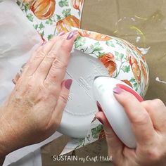 an older woman using a sewing machine to sew fabric on a flowered table cloth