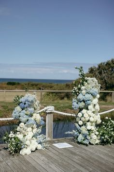 the wedding arch is decorated with blue and white flowers