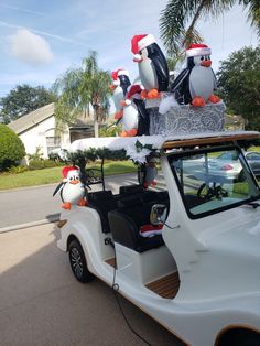 a golf cart decorated with penguins and santa hats