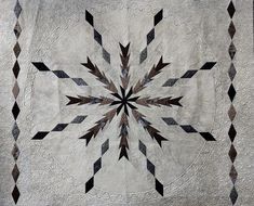 a black and white quilt with an intricate design on it's center piece is shown