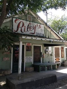 an old building with a sign on the side of it that says riley's tavern