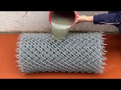 a person is pouring cement into a piece of barbed wire on top of an orange tile floor