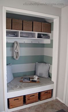 a mudroom with striped walls and storage bins