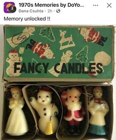 an open box with three candles inside of it and two figurines in the middle