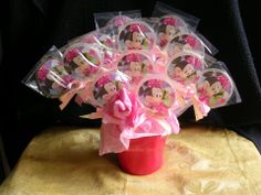 a red vase filled with minnie mouse cupcakes