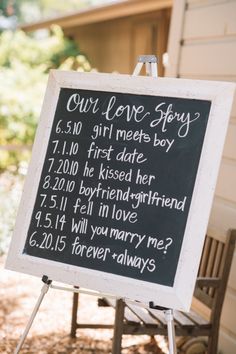 a chalkboard sign that says our love story is written on the side of a house