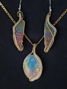 Wire wrapped rainbow dyed agate pendant and earring set. Beautiful detail in the wire wrapping. Both gold and silver colored wires wrap show off the cloud like appearance of the dyed agate. Your choice of gold or silver colored stainless steel chain in either 18 inches, 20 inches, 22 inches or 24 inches length. Pendant And Earring Set, Dyed Agate, Wire Wrap Jewelry Designs, Wire Wrap Jewelry, Wrap Jewelry, Jewelry To Make, Agate Pendant, The Wire, Wire Wrapped Jewelry