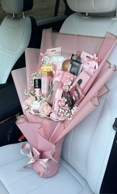 a pink bouquet sitting in the back seat of a car filled with personal care items