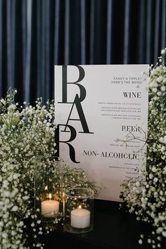 a table with candles, flowers and a sign on it that says barbar wine