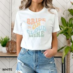 a woman wearing a white t - shirt with the words brip on cloud wine printed on it