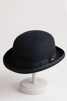 Top off your seasonal presentation with the charming Wool Bowler. Fashioned in 100% wool felt with its signature 3 3/4" tall dome crown and a wide grosgrain bow trim with pin, this classic design boasts a bound edge brim with a signature shape that's structured and curved. On the inside, there's a pleated satin lining, a clear plastic barrier, and a smooth comfort sweatband for a snug fit. Dare to look dashing. Classic Curved Brim Felt Hat For Fall, Classic Brimmed Felt Hat For Fall, Classic Felt Hat With Curved Brim For Fall, Classic Solid Boater Hat With Flat Brim, Classic Boater Hat With Flat Brim, Classic Fitted Solid Hat Bands, Elegant Wool Fedora For Winter, Elegant Wool Cloche Hat For Fall, Fitted Solid Cloche Hat