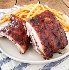 ribs and french fries on a plate with ketchup