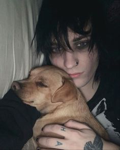 a woman laying in bed with a dog on her lap and looking at the camera