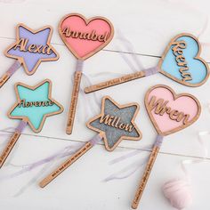 some cookies that are shaped like hearts and stars with names on them, all in different colors