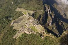 an aerial view of the ancient city of machaca picach in peru, with mountains and clouds behind it