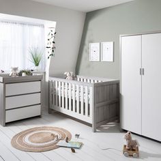 a baby's room with white and grey furniture