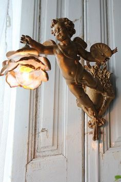 a statue on the side of a door with a light hanging from it's side