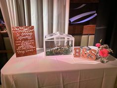 the table is set up with flowers and cards for guests to write their names on