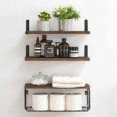 two shelves with towels, toiletries and plants on them