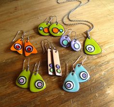 a collection of colorful earrings and pendants on a wooden table