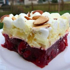 a piece of cake with whipped cream and cherries on top is sitting on a white plate