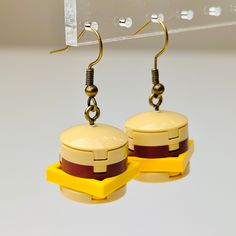 a pair of earrings made out of legos is hanging from a hook - up