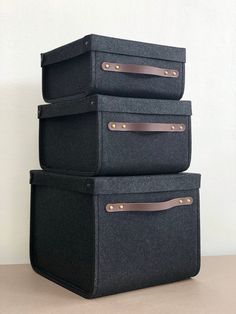 three black suitcases stacked on top of each other