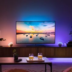 a flat screen tv sitting on top of a wooden table in front of a wall