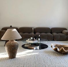 a living room filled with furniture and a glass coffee table in front of a couch