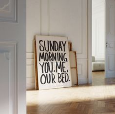 a sign that says sunday morning you me our bed on the floor in front of a door