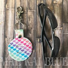 This handy tag can have be used many ways... on key chains, as a bag charm, on a backpack... and this one pulls double duty as it holds sunglasses securely when we can't find them on our head!  Sunnies arm slips right in the slots! Is approximately 3" x 2.25".  Sunglasses Keeper fob (from Bobbing for Appliqués) is stitched on fun marine vinyl or sparkle canvas fabrics with polyester thread. A few designs to choose from,       * rainbow hearts      * mermaid scales      * USA Flag      * red and Multicolor Keychain With Lobster Clasp For Everyday, Trendy Keychain With Lobster Clasp For Everyday Use, Trendy Keychains With Lobster Clasp For Everyday Use, Trendy Keychain With Lobster Clasp, Trendy Keychains With Lobster Clasp, Multicolor Keychain With Key Leash For Everyday Use, Trendy Travel Keychains With Key Clip, Multicolor Everyday Keychain, Multicolor Keychains With Key Clip For Everyday