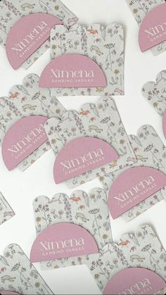 six pink and white tags with animals on them sitting next to each other in front of a table