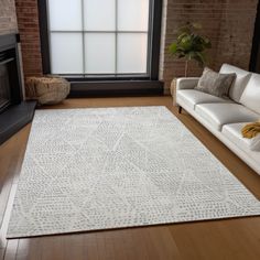 a living room with white furniture and a large rug in front of a window on the floor