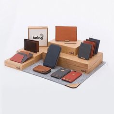 several different types of wallets on display in a wooden box with a white background