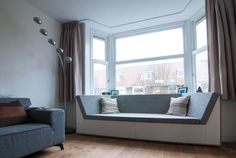 a living room filled with furniture and large windows